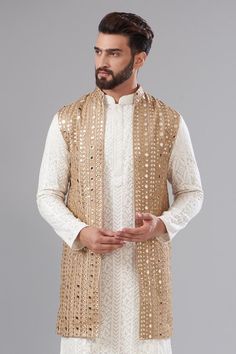 Gold open jacket with heavy mirror embroidery and a mandarin collar.
Components: 1
Pattern: Embroidered
Type Of Work: Mirror, Thread
Neckline: Mandarin collar
Sleeve Type: Sleeveless
Fabric: Georgette
Color: Gold
Other Details: 
Attached cotton lining
Note: Kurta and pant worn by the model is not for sale.
Occasion: Sangeet - Aza Fashions Traditional Nehru Jacket With Gota Work For Festive Occasions, Festive Traditional Nehru Jacket With Gota Work, Festive Nehru Jacket With Gota Work For Eid, Traditional Embroidered Vest For Wedding, Traditional Embroidered Wedding Vest, Traditional Wedding Vest For Festive Occasions, Traditional Wedding Vest For Festive Season, Traditional Festive Wedding Vest, Festive Bollywood Outerwear With Chikankari Embroidery