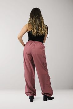 Elevate your street style with our Cargo Trousers, featuring a trendy pink tone and a comfortable, lightweight design perfect for the spring and summer seasons *FINAL SALE ITEM* Material & Care: Made from 100% polyester, our garments offer a lightweight and breathable feel. For best results, machine wash cold on gentle cycle and tumble dry low. Cool iron if needed. Do not bleach or dry clean. Size & Fit: Our model is wearing a size XS Trendy Pink Parachute Pants For Streetwear, Pink Parachute Pants With Cargo Pockets For Streetwear, Trendy Pink Parachute Pants For Spring, Casual Pink Parachute Pants For Summer, Pink Stretch Cargo Pants For Spring, Pink Casual Parachute Pants For Summer, Pink Parachute Pants With Elastic Waistband For Streetwear, Spring Pink Stretch Cargo Pants, Casual Pink Nylon Pants