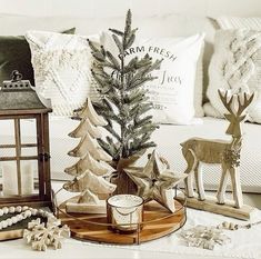 a living room filled with christmas decorations and decor on top of a wooden tray next to a lamp