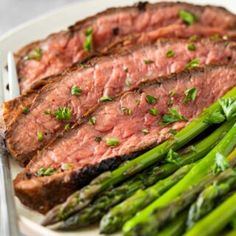 steak and asparagus on a white plate