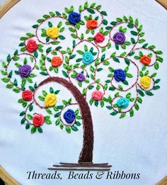 an embroidered tree with colorful flowers on it