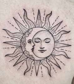 a sun and moon tattoo on the back of a man's chest, with his eyes closed