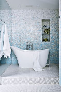 a white bath tub sitting next to a walk in shower