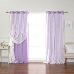 a living room filled with furniture and a window covered in purple drapes next to a white chair