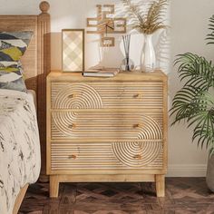 a wooden dresser sitting next to a bed in a room with plants and pictures on the wall