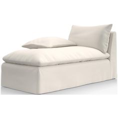 a white couch with two pillows on it's back and one pillow in the middle