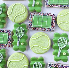 tennis themed cookies are arranged on a white table with green icing and sprinkles