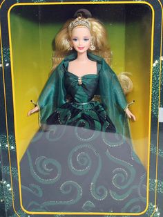 a barbie doll in a green dress and tiara with gold trimmings on her head