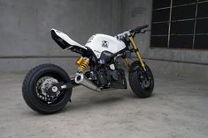 a white and black motorcycle parked in a garage