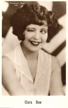 an old black and white photo of a woman smiling