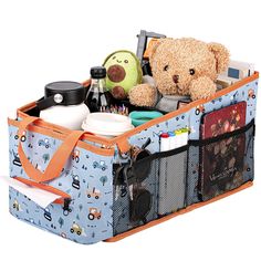 a teddy bear sitting inside of a blue suitcase filled with stuff and other things in it