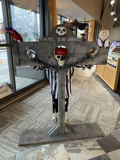 a wooden sign with skulls and bones hanging from it's sides in front of a store window