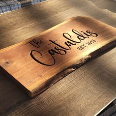 a wooden sign sitting on top of a table next to a blue checkered blanket