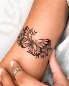 a woman's arm with a butterfly tattoo on it