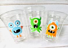 three plastic cups with different colored monsters on them