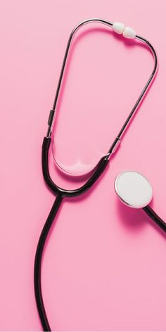 a stethoscope laying on top of a pink surface