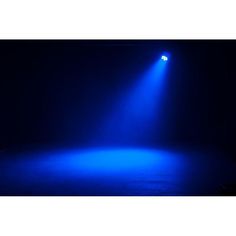 a blue light shines brightly on a dark stage with the floor lit up by two spotlights