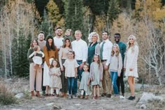 a large family poses for a photo in the woods