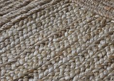 a close up view of the texture of a woven area rug, which has been made from natural materials