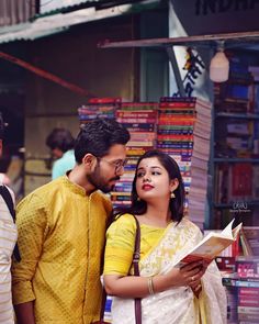 a man and woman standing in front of a book store looking at each other's books