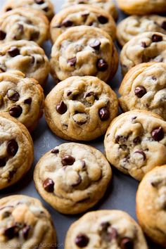 chocolate chip cookies are lined up on a baking sheet