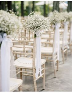 the aisle is lined with chairs and decorated with baby's breath flowers in white