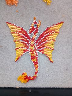 the beaded butterfly is sitting on the floor