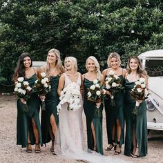 a group of women standing next to each other in front of a white car and holding bouquets