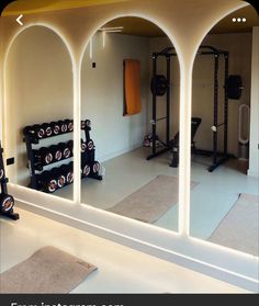 a gym with exercise equipment and mirrors in it