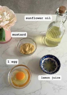 ingredients to make lemon custard in small glass bowls on a marble countertop