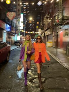 two women walking down the street at night