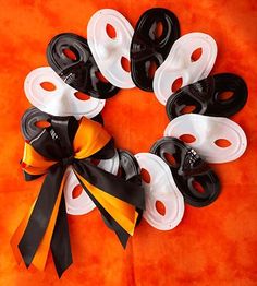 a black and white wreath made out of buttons on an orange background with the word hello kitty written across it