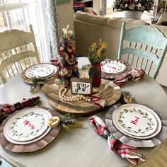 the table is set for christmas with plates and napkins