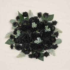 a bunch of black flowers with green leaves