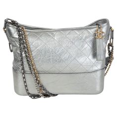 100% authentic Chanel Gabrielle Medium Hobo Bag in metallic silver aged calfskin featuring doubel chain shoulder-strap in gold-tone, silver-tone & ruthenium-finish metal. Opens with a CC zipper on top and is lined in red grosgrain fabric with one zipper pocket against the back and two open pockets against the front with lipstick pocket in the middle. Has been carried with one scuff on the side. Overall in excellent condition. Comes with dust bag. Fall/winter 2017 collection. Measurements Height Luxury Gray Shoulder Bag With Branded Hardware, Silver Designer Bag, Balenciaga Purse, Ruffles Bag, Chanel Gabrielle, Celine Shoulder Bag, Structured Shoulder, Snake Skin Bag, Gabrielle Chanel