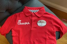 a red polo shirt with the word chick girl on it and a checkered collar