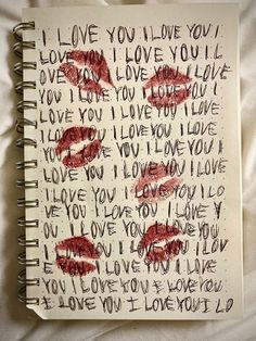 an open notebook with writing on it and two red lips sticking out of the pages