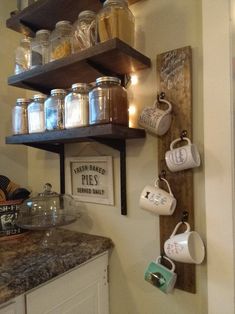 the shelves are filled with jars and mugs on top of each other in this kitchen