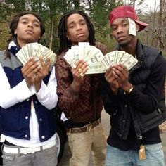 three young men holding money in their hands