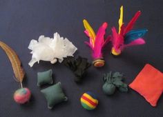 there are many different types of toys on the table together, including feathers and balls