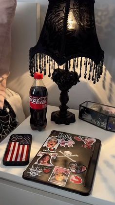 a coca cola bottle sitting on top of a table next to a lamp and other items