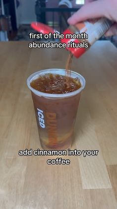 someone pouring caramel into a cup with the caption, first of the month abundance rituals add cinnamon into your coffee