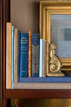 there is a bookshelf with many different books on it and a mirror in the background