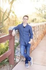 a man standing on a bridge next to a wooden fence