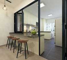 a kitchen with three stools in front of the counter