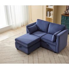 a blue sectional sofa sitting on top of a rug