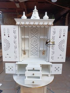 an ornate white cabinet with gold accents on the top and bottom, sitting in a warehouse