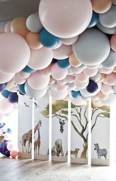 a room filled with balloons and animals on the wall