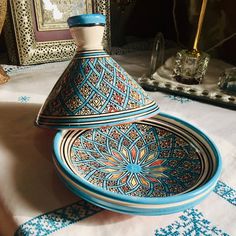 a blue and white vase sitting on top of a table next to a mirror with an ornate design