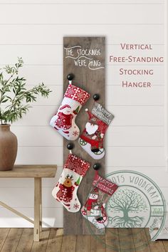 a christmas stocking hanging on a wooden sign with santa claus and reindeer stockings attached to it